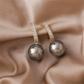 Elegant gray pearl and diamond drop earrings, featuring 18K gold plating and sparkling cubic zirconia accents.
